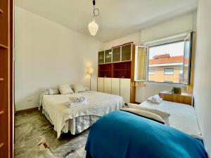 een slaapkamer met 2 bedden en een raam bij [50 metri dal Mare] Trilocale in Centro con A/C in Loano
