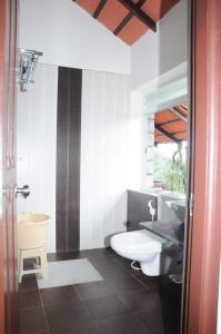 ein Badezimmer mit einem weißen WC und einem Waschbecken in der Unterkunft Foothills Homestay in Chikmagalur