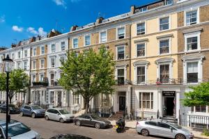 een groot gebouw met auto's geparkeerd voor het bij 2-Bedroom Victorian Apartment in Kensington in Londen