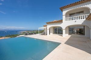 a villa with a swimming pool next to the ocean at Les Agathea in Saint-Tropez