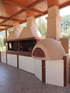 uma cozinha exterior com um forno de pizza num edifício em Aroma Studios and Apartments em Vourvourou