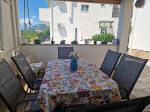 a table with a table cloth with a vase on it at La Mer Apartments Kotor in Kotor