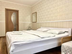 ein Schlafzimmer mit einem großen Bett mit weißer Bettwäsche in der Unterkunft ApartPoltava 100 квадратних метрів затишку в серці Полтави, Корпусний парк, Банківський ЧЕК in Poltawa