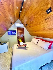 a bedroom with a large bed with a wooden ceiling at Pousada Vale da Neblina in Ubajara