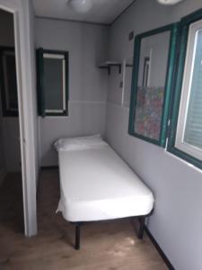 メタポントにあるCamping village Internazionaleの窓付きの客室で、白いベンチが備わります。