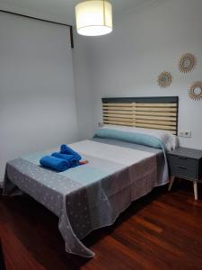 een slaapkamer met een bed met blauwe handdoeken bij Centrico y acogedor, Posibilidad parking 10 euros dia in Vigo