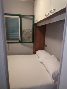 a small bedroom with a bed and a window at Camping village Internazionale in Metaponto