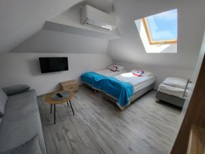 een kleine kamer met een bed en een bank bij Błękitna Laguna 2 in Rewa