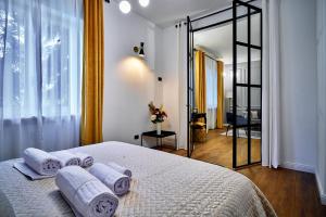1 dormitorio con 1 cama con toallas en LILIENBLUM CHIC Apartment ChicLife - Borgo Santa Caterina, en Bérgamo