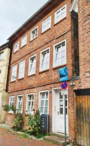 un edificio de ladrillo con una puerta blanca y un letrero de la calle en Ferienwohnung Till, en Mölln