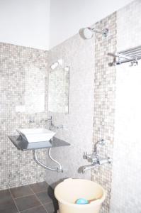 ein Bad mit einem Waschbecken, einer Dusche und einem WC in der Unterkunft Foothills Homestay in Chikmagalur