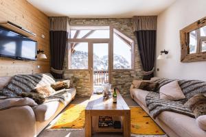 uma sala de estar com dois sofás e uma televisão em Luxury Chalet with sauna by Avoriaz Chalets em Avoriaz