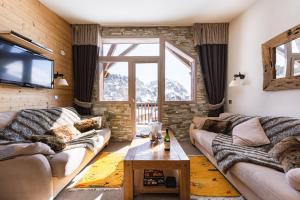 Luxury Chalet with sauna by Avoriaz Chalets في أفورياز: غرفة معيشة مع كنبتين وتلفزيون