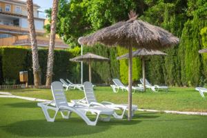 Un grupo de sillas y sombrillas en el césped. en Casa Mediterránea, en Águilas