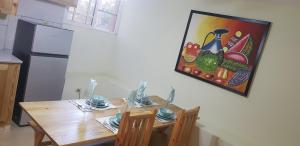 una cocina con una mesa y una pintura en la pared en Private and quiet room, en Jarabacoa