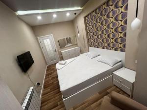 a small room with a bed and a tv at Park Azure 0568 in Baku