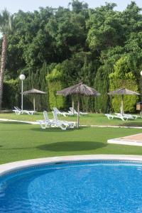 einen Pool mit Liegestühlen und Sonnenschirmen in der Unterkunft Casa Mediterránea in Águilas