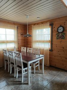 uma sala de jantar com mesa e cadeiras e um relógio em VILLA OLGA em Tahkovuori