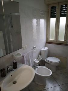 bagno bianco con lavandino e servizi igienici di The Sail Apartment - Marzamemi a Marzamemi