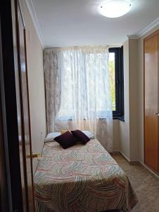 małą sypialnię z łóżkiem z oknem w obiekcie Apartamento en la Ciudad de las Artes y las Ciencias w Walencji