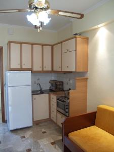 a kitchen with a white refrigerator and a couch at La Fontaine Apartments in Kandia