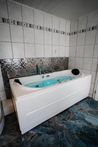 a white bath tub in a tiled bathroom at Timeout Royal in Ellar