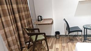 ein Zimmer mit einem Tisch und 2 Stühlen sowie einem Tisch und Stühlen in der Unterkunft Sapphero Akshar Inn- Jamnagar in Jamnagar