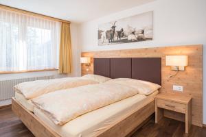 a bedroom with a large bed with a wooden headboard at Ferienhaus Felicé in Zermatt