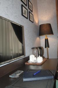 a desk in a hotel room with a lamp and a book at Hotel 1883 in Baku