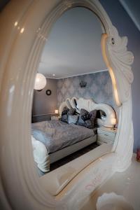 a bedroom with a bed with a large mirror at Timeout Royal in Ellar