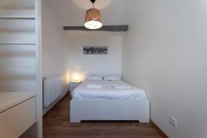Dormitorio pequeño con cama blanca y lámpara en Caneta Marina - Familial et Lumineux au Port de Caneta, Wi-Fi, en Hendaya