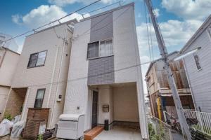 een wit huis met een kraan ervoor bij Sumida Ward - House - Vacation STAY 89066 in Tokyo