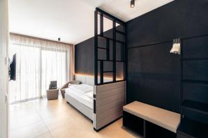 1 dormitorio con cama y pared negra en Villa Weingarten, en Caldaro