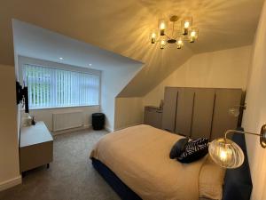 - une chambre avec un grand lit et un lustre dans l'établissement Bon Ella, à Torquay