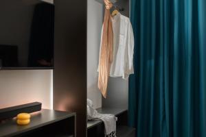 a white shirt hanging on a rack next to a blue curtain at 25 Dikaiosinis Ave. in Heraklio Town +40 photos