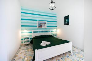 a bedroom with a bed and a blue and white wall at Torre Turbolo Apartments in Massa Lubrense