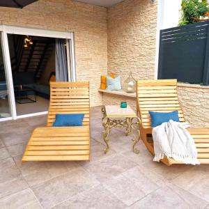 2 sillas de madera y una mesa en el patio en Villa Brajkovic-near the sea and Rovinj center en Rovinj