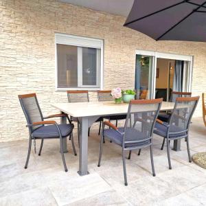 a dining table and chairs with an umbrella at Villa Brajkovic-near the sea and Rovinj center in Rovinj