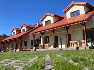 dom z czerwonym dachem i trawnikiem w obiekcie Lili Domki Letniskowe w Karwii