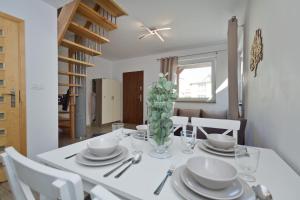 een eetkamer met een witte tafel en witte stoelen bij Lili Domki Letniskowe in Karwia