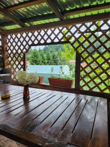 una mesa de madera con un jarrón de flores. en Casa din livadă - Cazare Măgheruș, en Topliţa