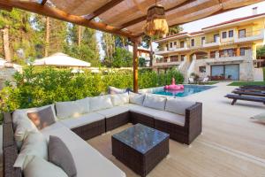 a patio with a couch and a table and a pool at Selia Villa Pefkochori in Pefkochori