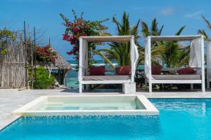 a swimming pool with two chairs sitting next to a pool at Visiwa Beach Resort in Watamu