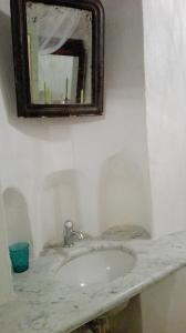 y baño con lavabo de mármol y espejo. en B&B La Fontanina, en Siena