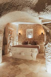 een slaapkamer met een groot bed in een stenen muur bij Harem Suites Cappadocia in Uchisar