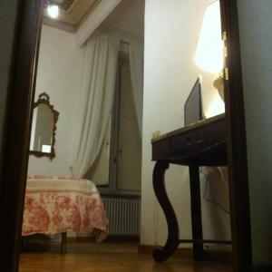 um quarto com um piano, um espelho e uma cama em B&B La Fontanina em Siena