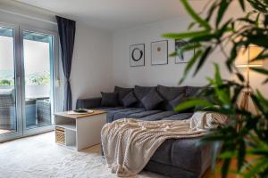 Sala de estar con sofá gris y mesa en Hegau-Refugium: Am Bodensee & der Schweizer Grenze en Singen