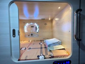 a small room with a bed and a mirror at Sleep Cubee Hostel in Hong Kong