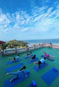 un grupo de personas haciendo yoga en la azotea de un complejo en Ko Tao Resort Paradise Zone - SHA Plus, en Ko Tao