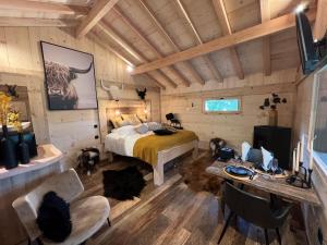 een slaapkamer met een bed, een bureau en stoelen bij Les Écrins du Val de Mouthe, JURA 